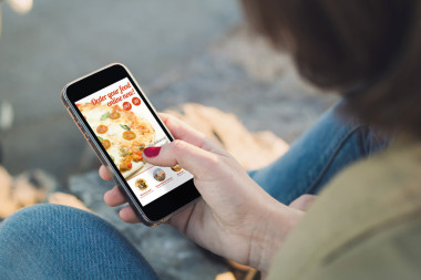 訂購比薩餅與智能手機(jī)的女人圖片