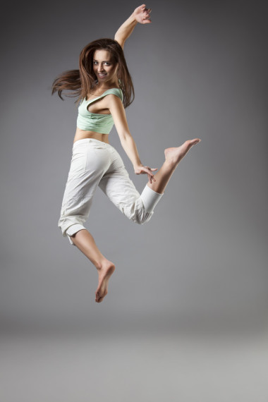 灰色背景上的美麗女孩舞蹈