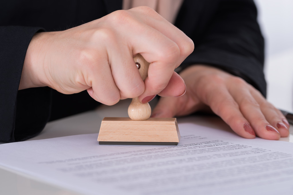 在文档上使用压模的商人 在文档上使用压模的商人