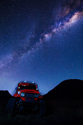 银河系与在印度尼西亚爪哇的 Mt.Bromo,East 辆红色的车