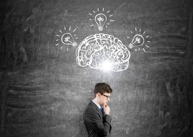 黑色黑板上畫著大腦和三個燈泡