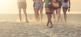 群的海滩上散步，在日落时的朋友