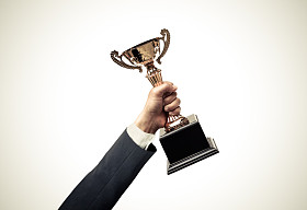 一名商人手拿金色奖杯的手