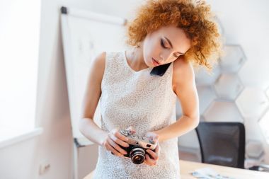 女?dāng)z影師使用老式相機和談移動電話