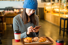 亚洲女人在咖啡馆中使用手机