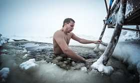 年轻人在冰洞中游泳图片