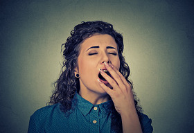 昏昏欲睡的年轻女人张着大嘴打哈欠眼睛闭