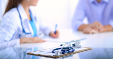 坐在桌子上的男性患者的醫(yī)生女人