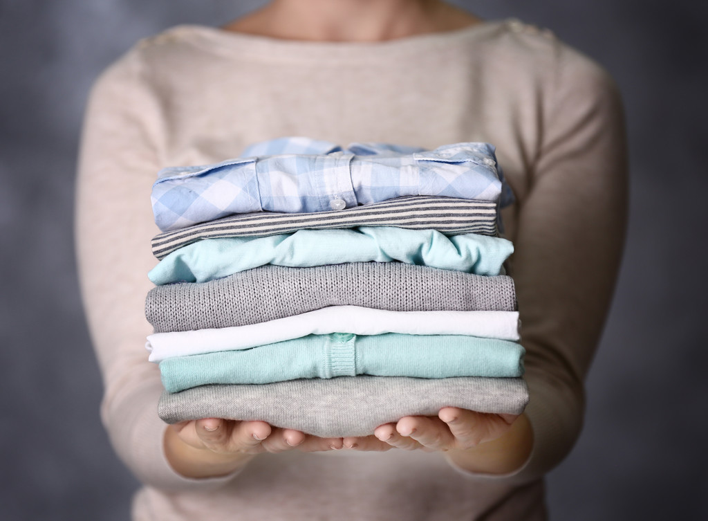 女人抱着洗涤和干燥的衣服  女人抱着洗涤和干燥的衣服