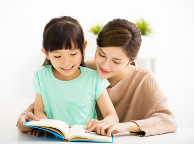 快樂的小女孩和她媽媽一起看書