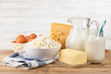 木制的桌子上的牛奶罐照片