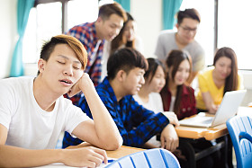 男学生在教室里桌子上睡着图片