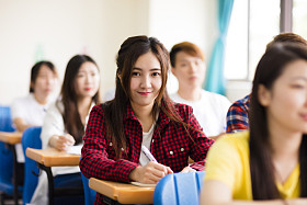 微笑着坐在一起的同学的女大学生