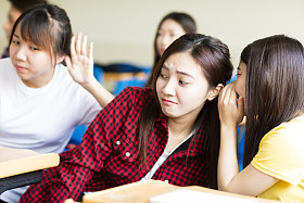 快乐的学生女孩在教室里闲聊图片