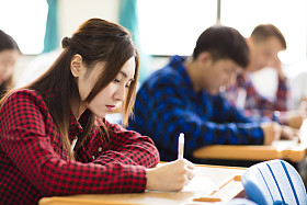 女大学生坐和考试在教室