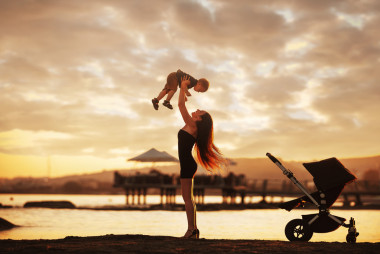 媽媽和寶寶在日落之后的海灘上