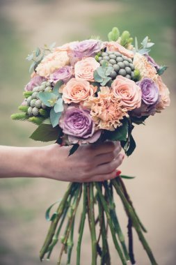 婚禮花束特寫鏡頭，美麗溫柔婚禮花束的混合花和新娘的手