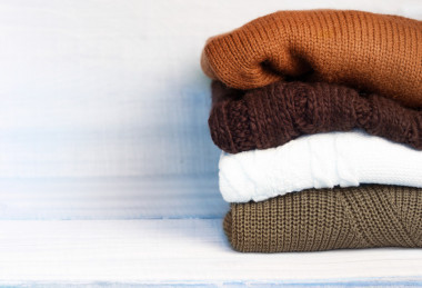 木制的背景上桩针织的冬天秋天的衣服