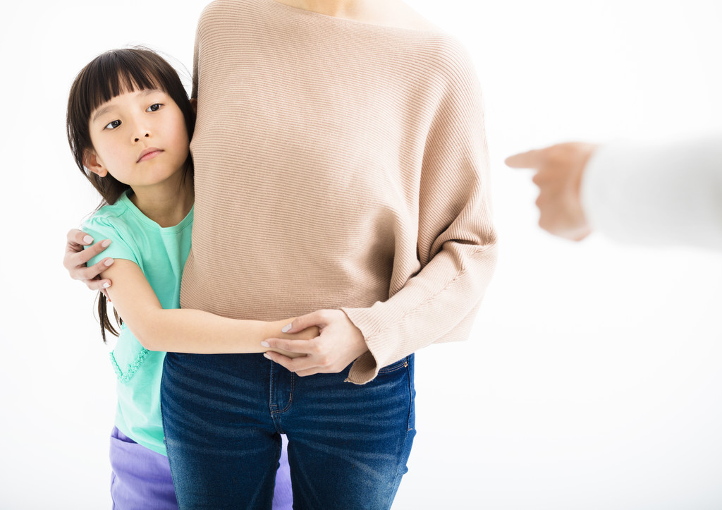 害怕的女儿躲在母亲生气的父亲从后面 害怕的女儿躲在母亲生气的父亲从后面