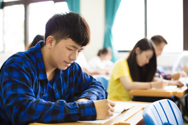 在課堂上寫筆記的一群年輕學(xué)生  