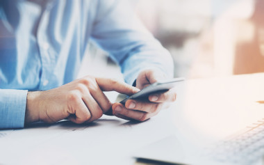 辦公室世界, 時(shí)間剎車。商人在木桌工作與新的商業(yè)項(xiàng)目。人觸摸屏幕現(xiàn)代手機(jī)。臥式樣機(jī)。耀斑, 電影效果