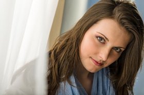 年轻女子黑发看相机帘子后面图片