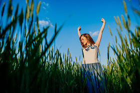 漂亮的女孩站在麦田照片