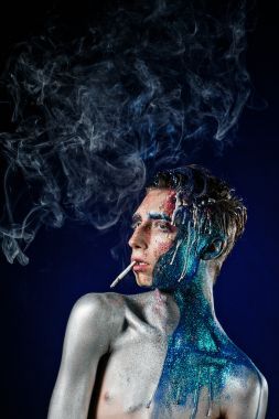 疯狂的年轻人脸上艺术吸烟和享受。反常的人