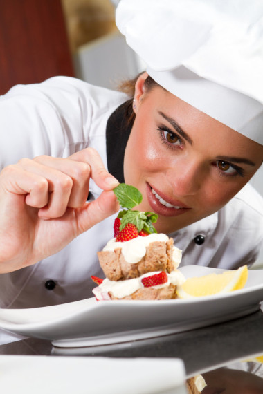 美丽的年轻厨师装饰甜点
