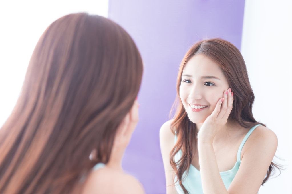 微笑的女人看镜子