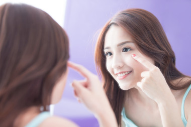 微笑的女人觸摸眼睛圖片