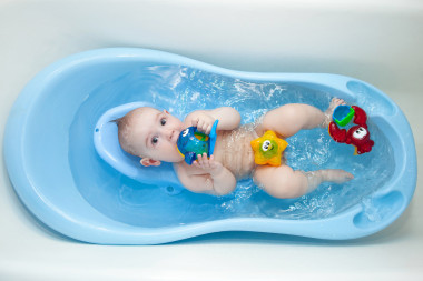 一個(gè)小孩沐浴在藍(lán)色的沐浴玩具