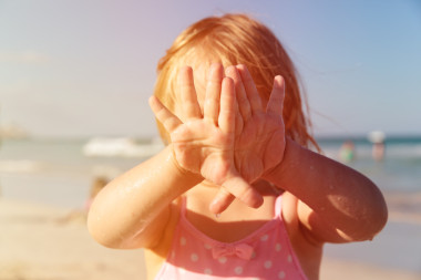 顯示濕的手在海灘的小女孩圖片