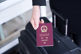 手拿着中国护照，准备好去旅