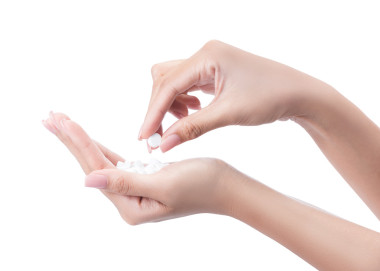 一個(gè)女人牽著一顆藥丸，孤立在白色的手