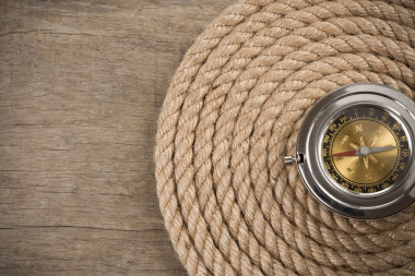船舶繩索和木背景上指南針