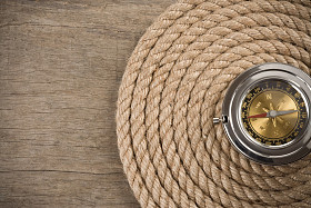 船舶绳索和木背景上指南针