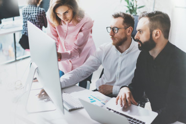 項目經(jīng)理團(tuán)隊工作新理念。年輕的商業(yè)船員與啟動現(xiàn)代工作室工作。在桌子上，顯示演示文稿的臺式計算機(jī)。模糊的影片效果。寬