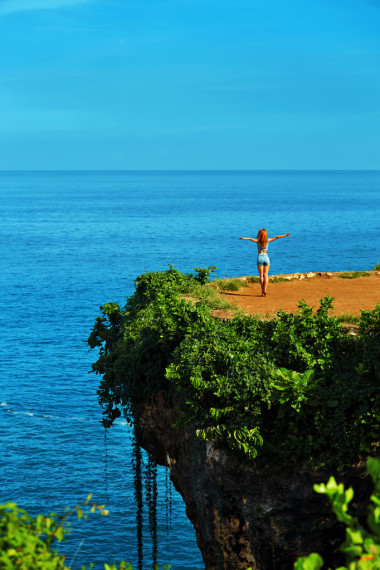 自然景觀。熱帶的懸崖之上，海巖石島上的女人