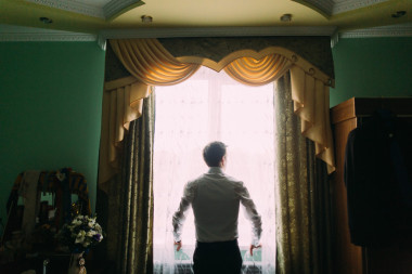 站在窗邊的英俊男子在白色襯衫的剪影