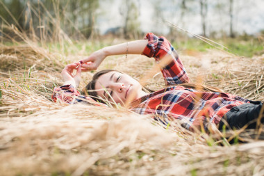 幸福的女人衬衫躺在稻草上