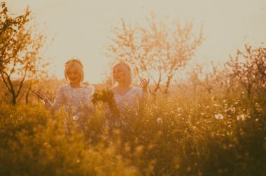 雙胞胎女孩伸展向天空的手