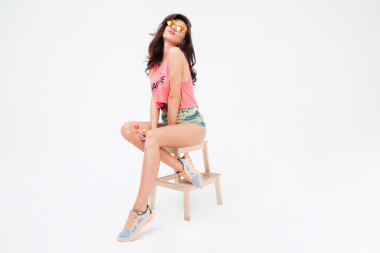 在太陽鏡和糖果坐在椅子上有魅力的女人