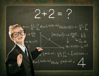 年轻聪明的科学家儿童学生写在黑板上