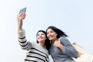 两个亚洲妇女采取自拍照图片