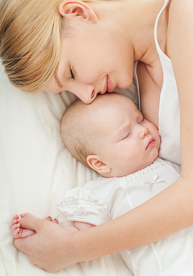 年轻的母亲和她的孩子睡在床上
