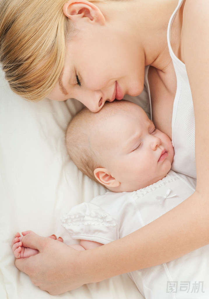 年輕的母親和她的孩子睡在床上