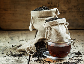 玻璃透明杯红茶和干燥的茶叶袋