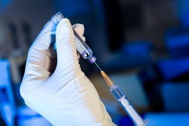 科學(xué)家使用注射器吸疫苗，手套