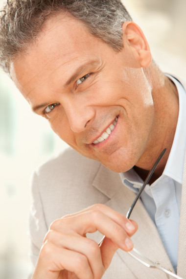 风度翩翩的微笑商人与办公室的眼镜肖像